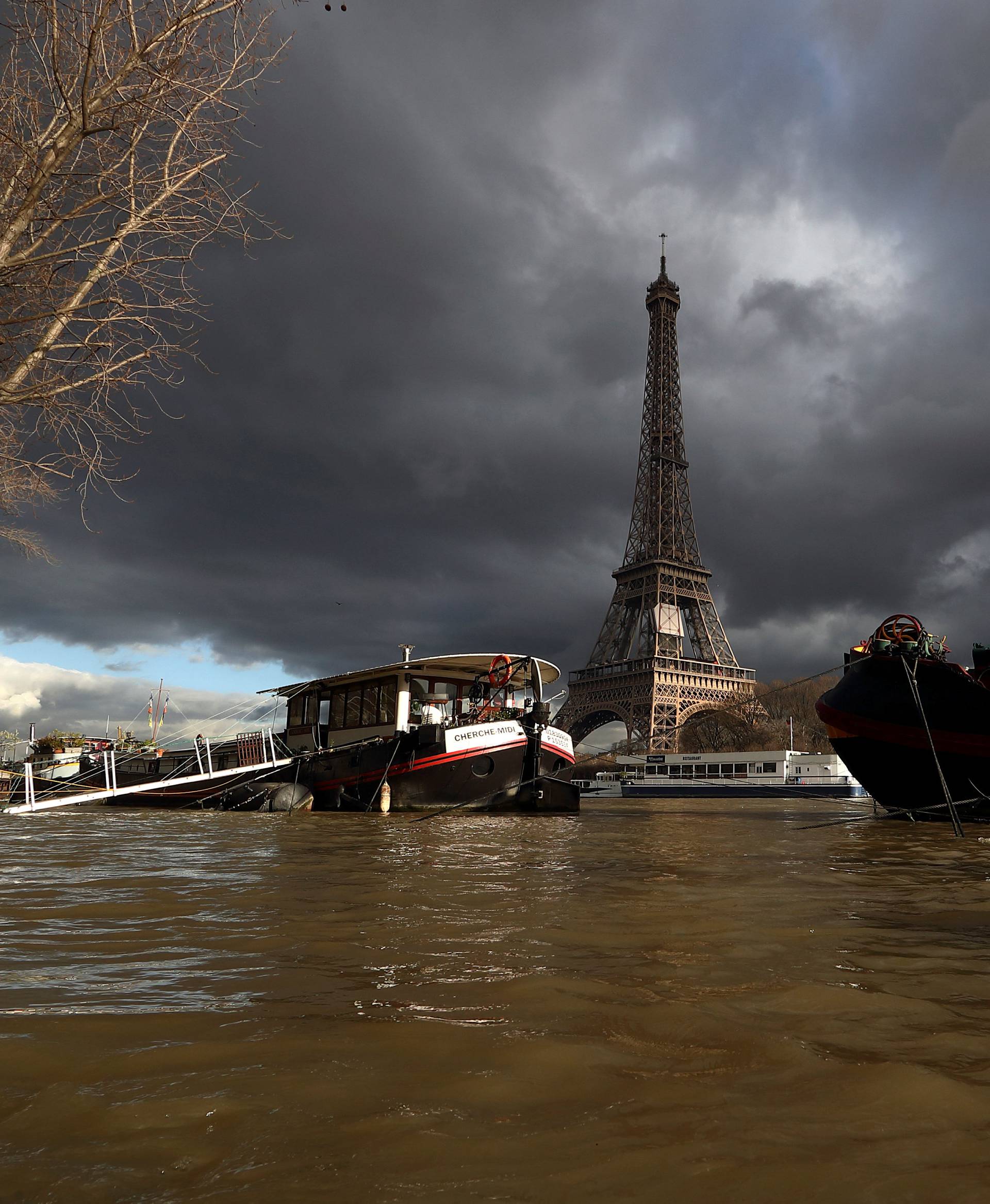 A view shows peniche houseboats moored and the Eiffel Tower along the flooded banks of the River Seine after days of almost non-stop rain caused flooding in the country in Paris