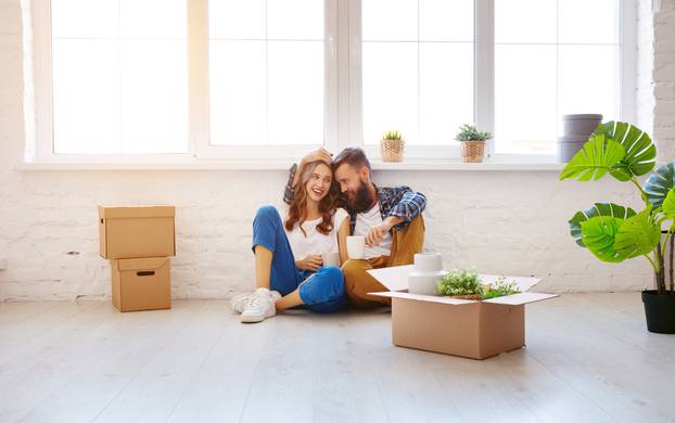 happy young married couple moves to new apartment