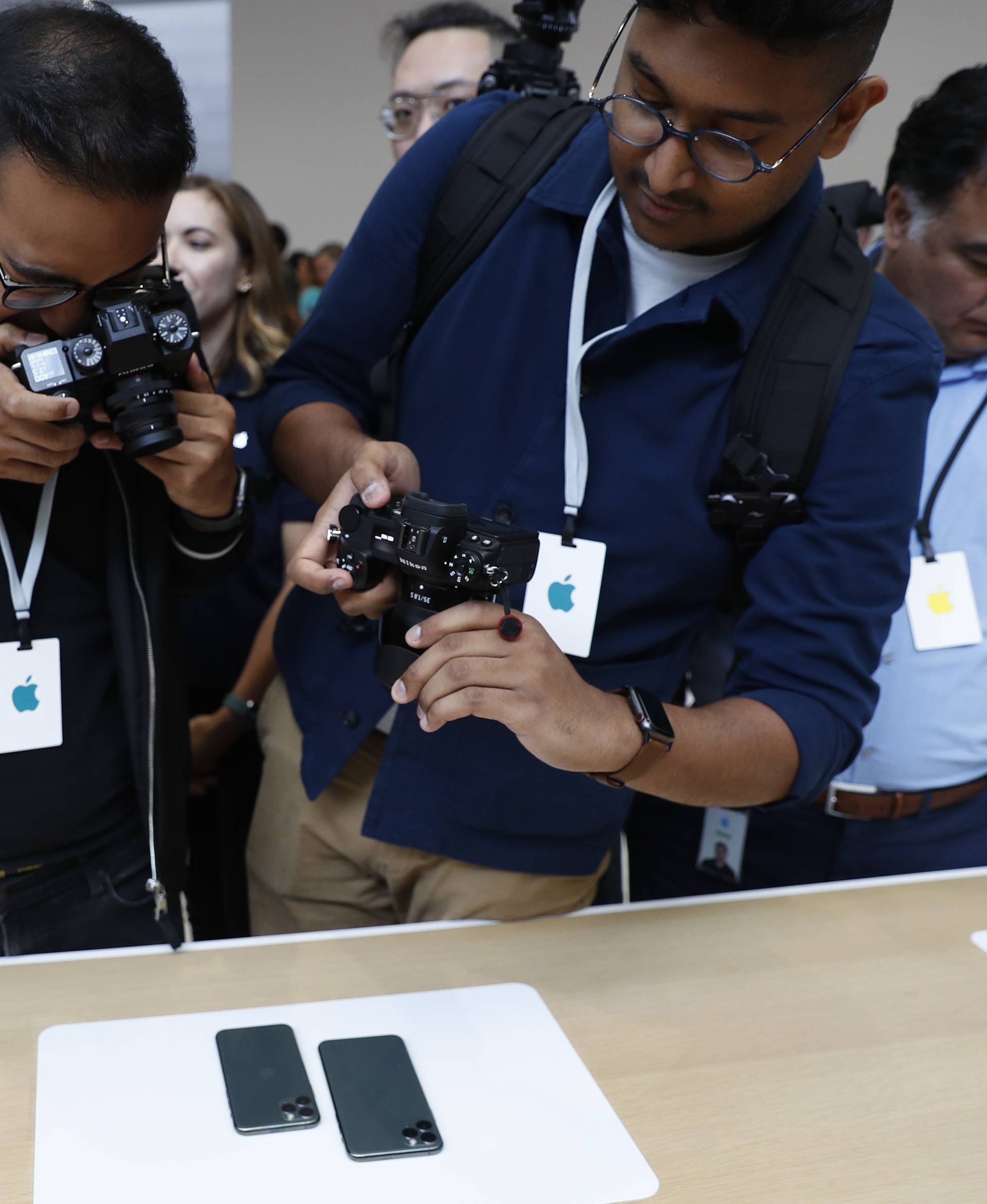 People take photos of new iPhones in the demonstration room at an Apple event at their headquarters in Cupertino