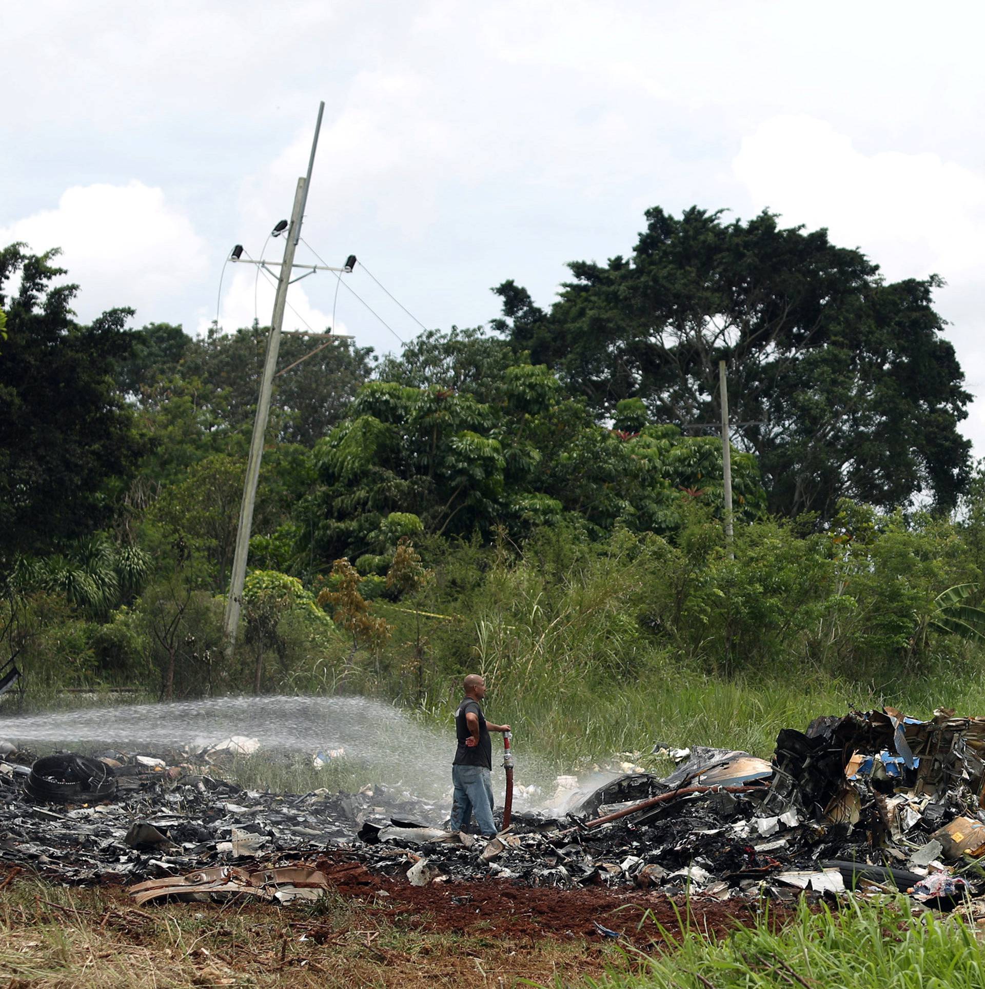 Rescue team members work in the wreckage of a Boeing 737 plane that crashed in the agricultural area of Boyeros