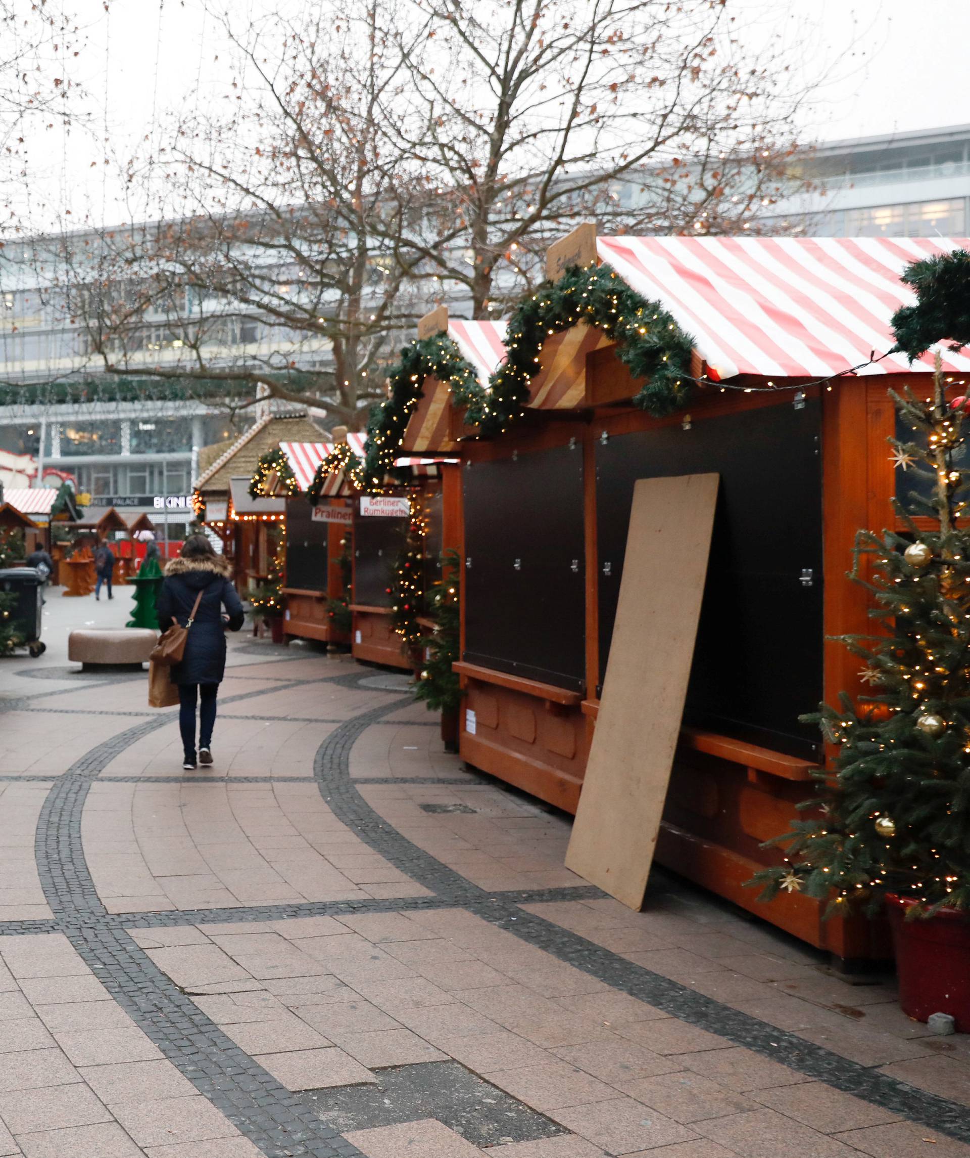 A woman walks near the area where a truck which ploughed into a crowded Christmas market in the German capital last night in Berlin