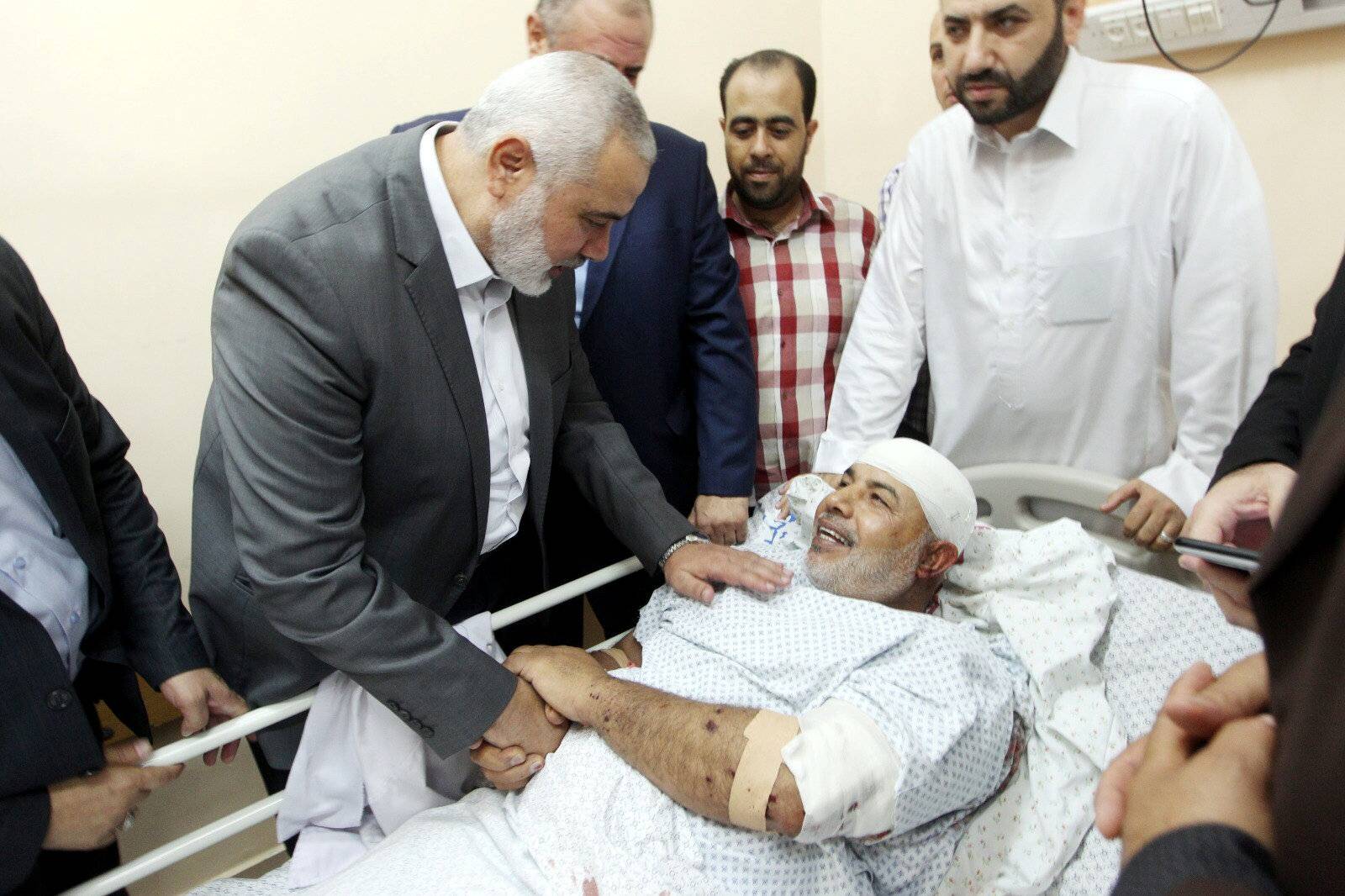 Hamas Chief Ismail Haniyeh visits Hamas' security chief in the Gaza Strip Tawfeeq Abu Naeem as he lies on a bed at a hospital in Gaza City