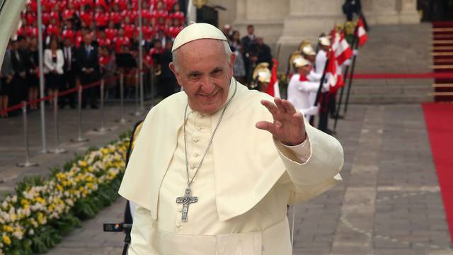 Pope Francis waves as he leaves the presidential palace in Lima