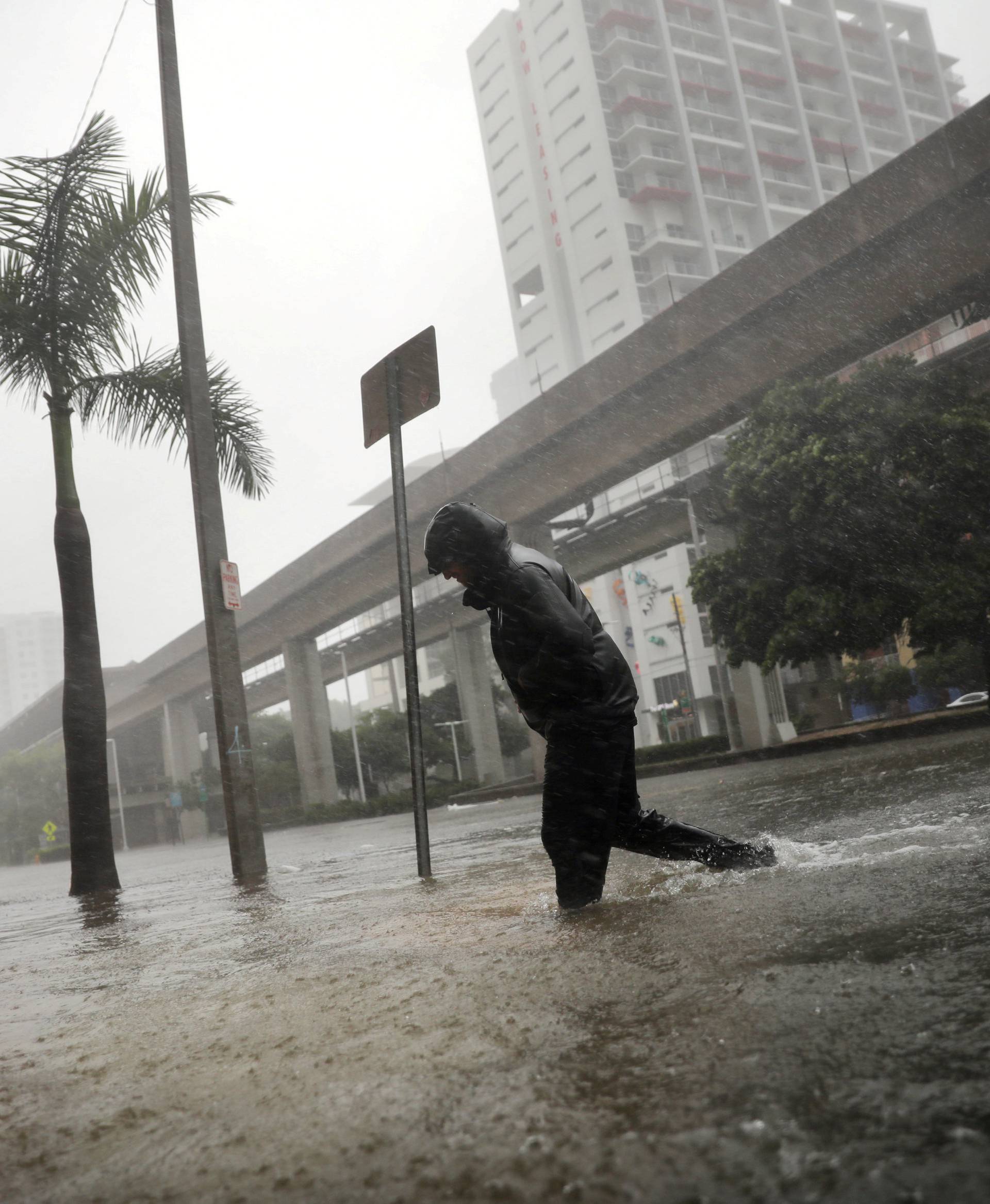 A local resident walks across a flooded street in downtown Miami as Hurricane Irma arrives at south Florida