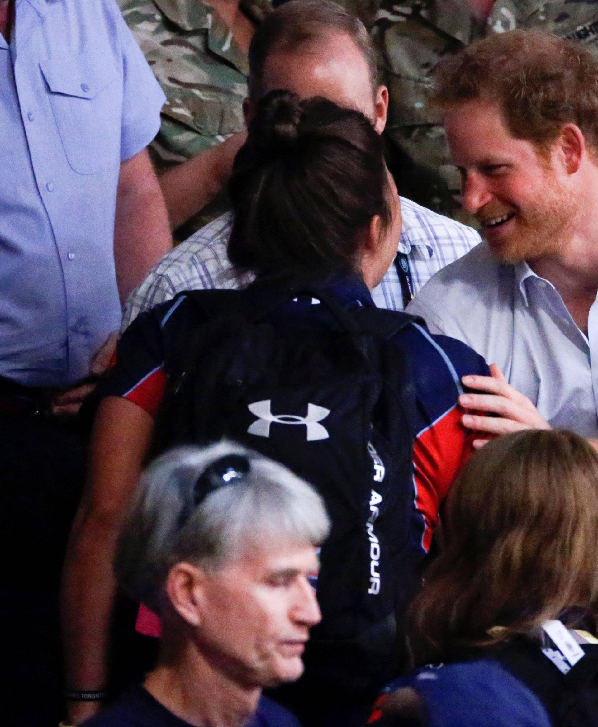 Britain's Prince Harry speaks to Elizabeth Marks of the U.S. during the bronze medal wheelchair rugby match at the Invictus Games in Orlando, Florida, U.S.