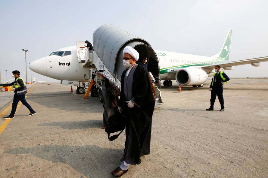 A cleric man wears a protective mask amid concerns over the coronavirus (COVID-19) spread, at Najaf airport in the holy city of Najaf