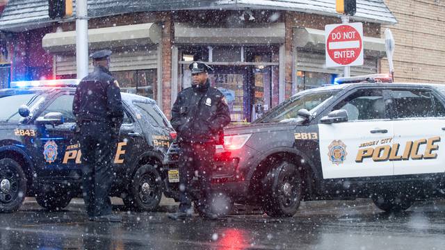 Jersey City police work at the scene the day after an hours-long gun battle with two men around a kosher market in Jersey City, New Jersey