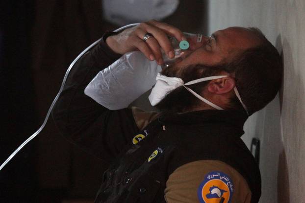 A civil defense member breathes through an oxygen mask, after what rescue workers described as a suspected gas attack in the town of Khan Sheikhoun in rebel-held Idlib