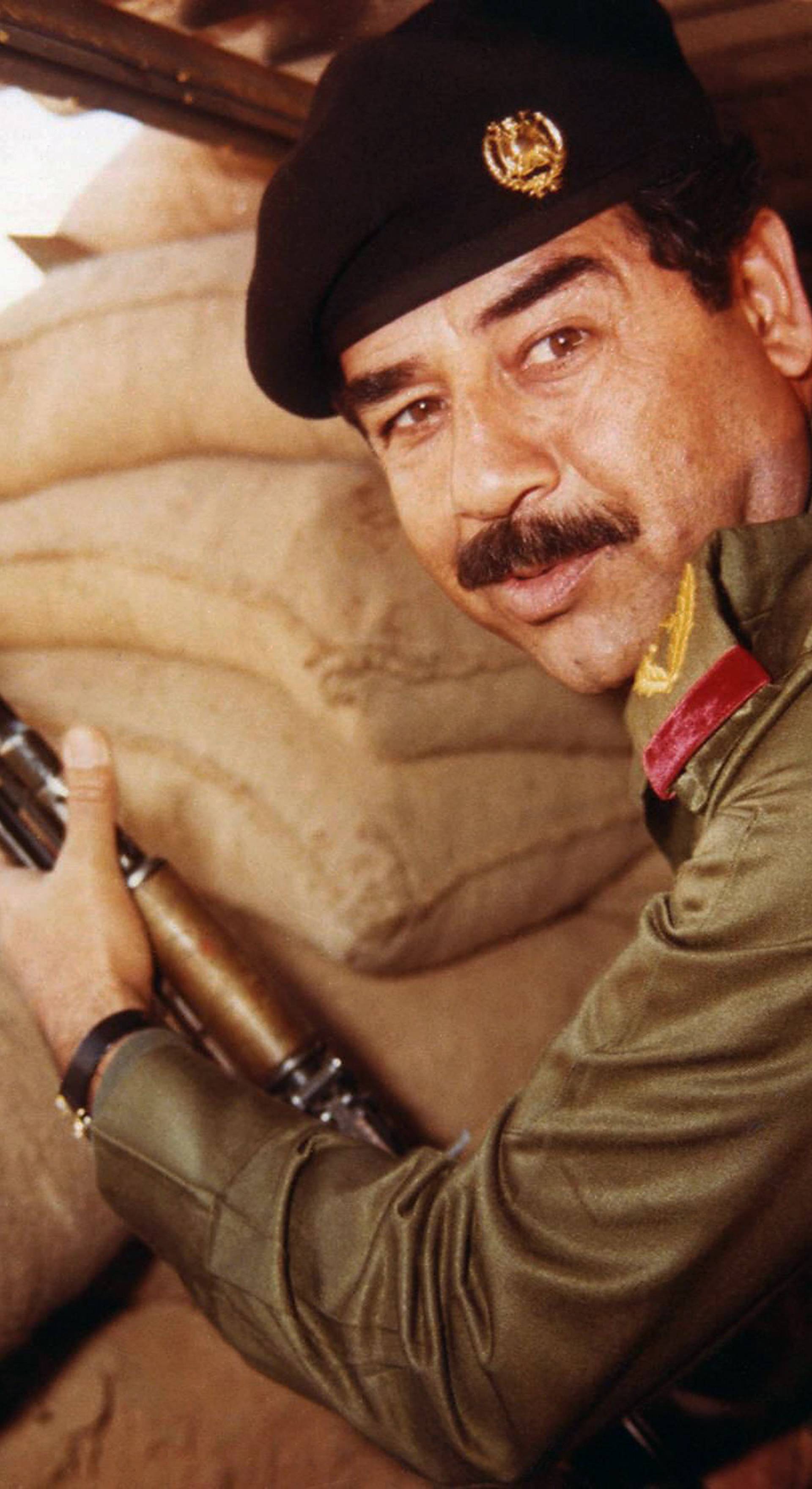 Iraq: Saddam Hussein, President of Iraq 1979-2003, posing with a rifle in a dugout during the Iran-Iraq War (1980-1988) <br/><br/>