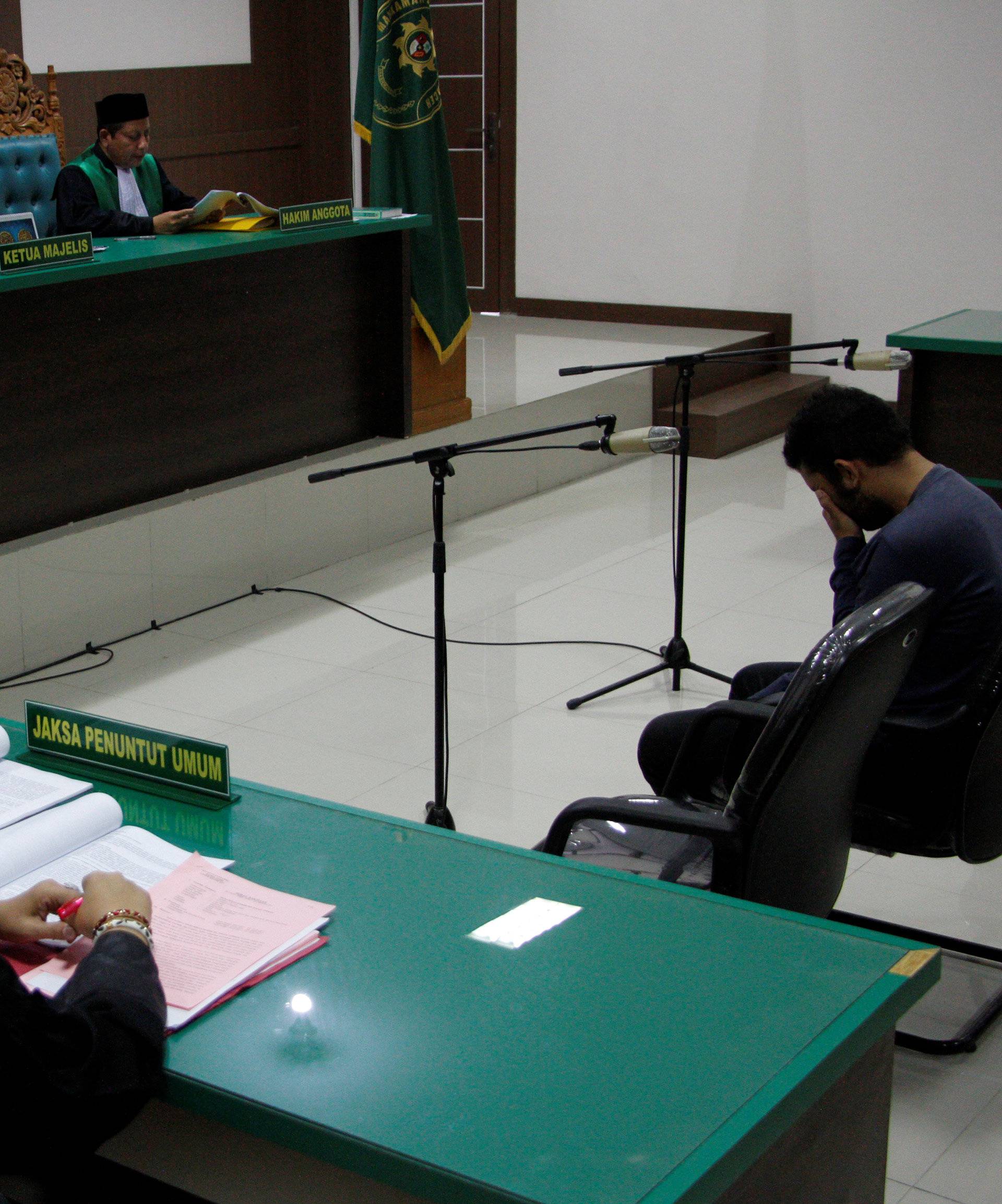 An Indonesian man sits in an Islamic court, one of the two men sentenced to 85 lashes of the cane for having sex together, in Banda Aceh, Aceh province, Indonesia