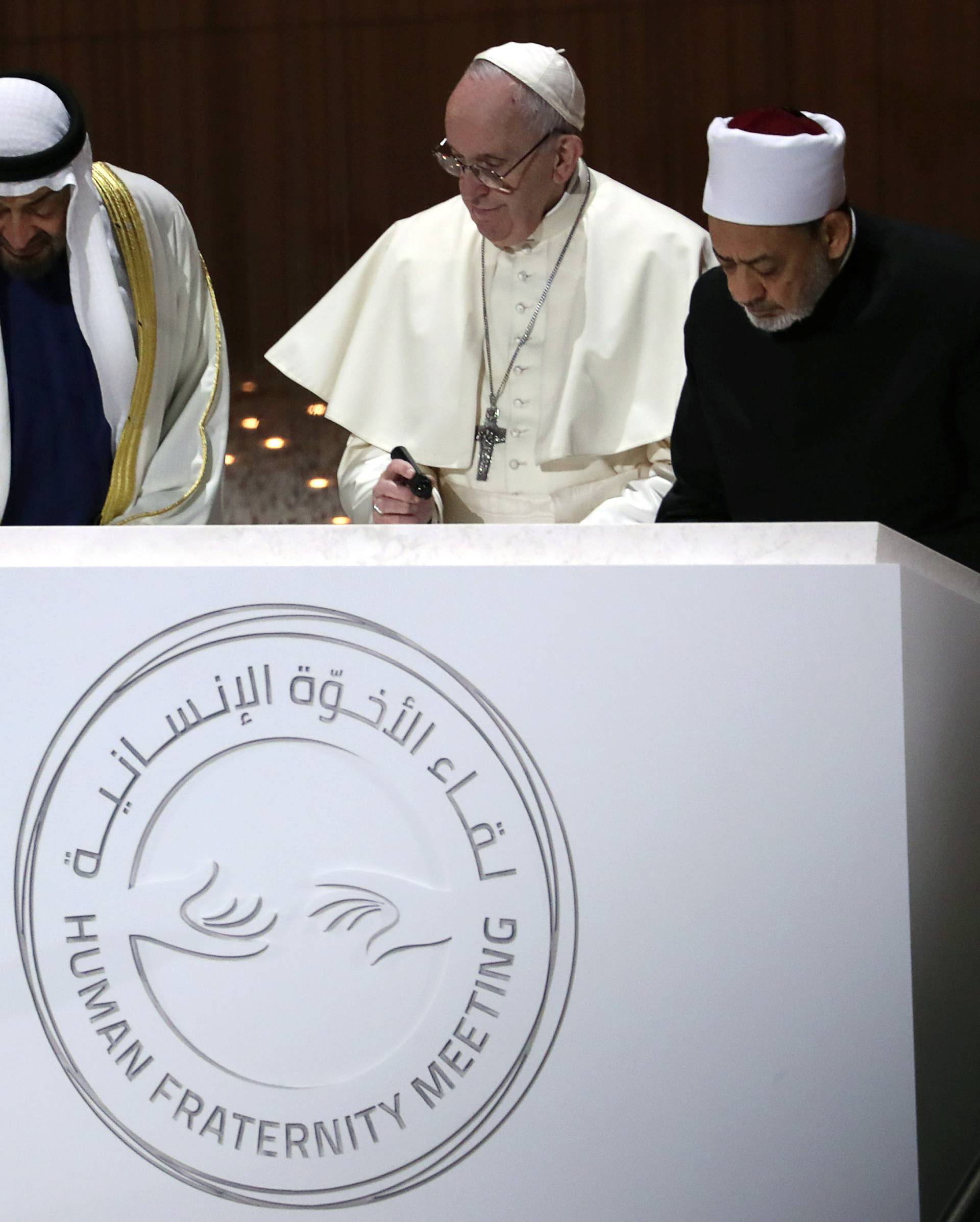 Pope Francis, Abu Dhabi's Crown Prince Mohammed bin Zayed Al-Nahyan and Grand Imam of al-Azhar Sheikh Ahmed al-Tayeb sign a document during an inter-religious meeting at the Founder's Memorial in Abu Dhabi