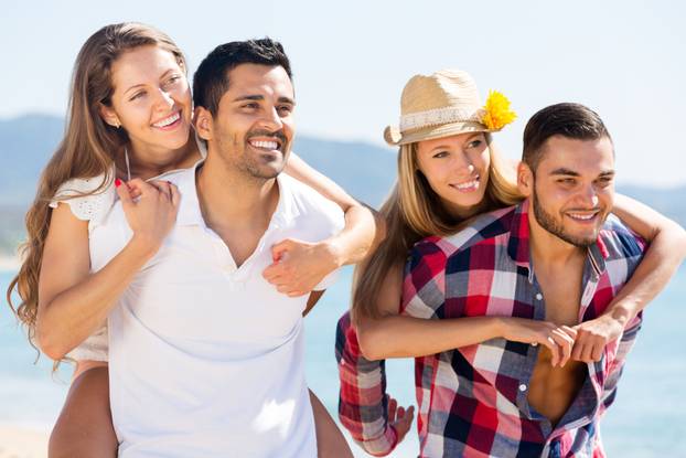 hugging couples on beach