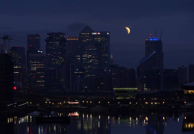 Pomr?ina Mjeseca vidljiva iznad Canary Wharfa u Londonu