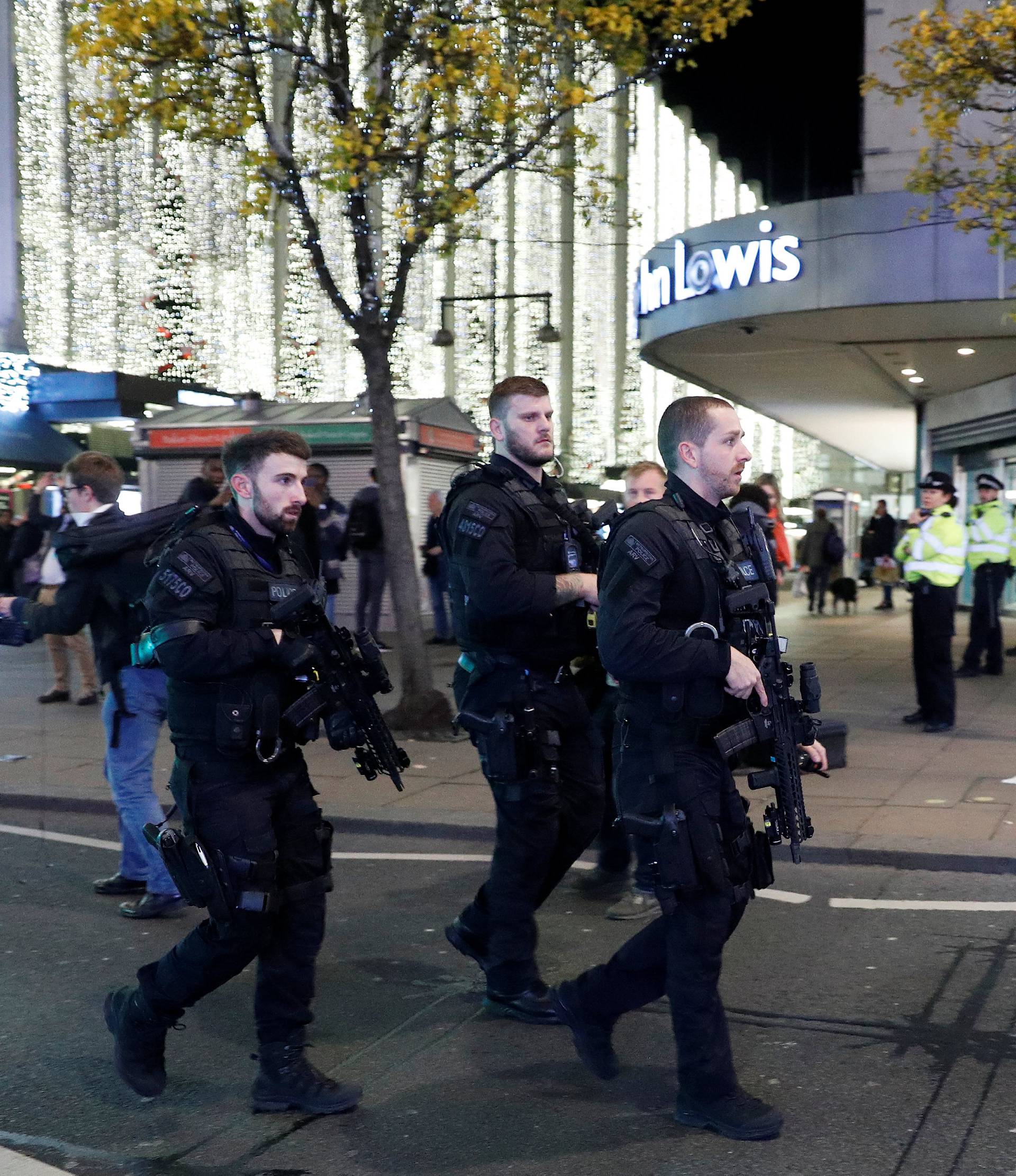 Armed police officers walk along Oxford Street, London