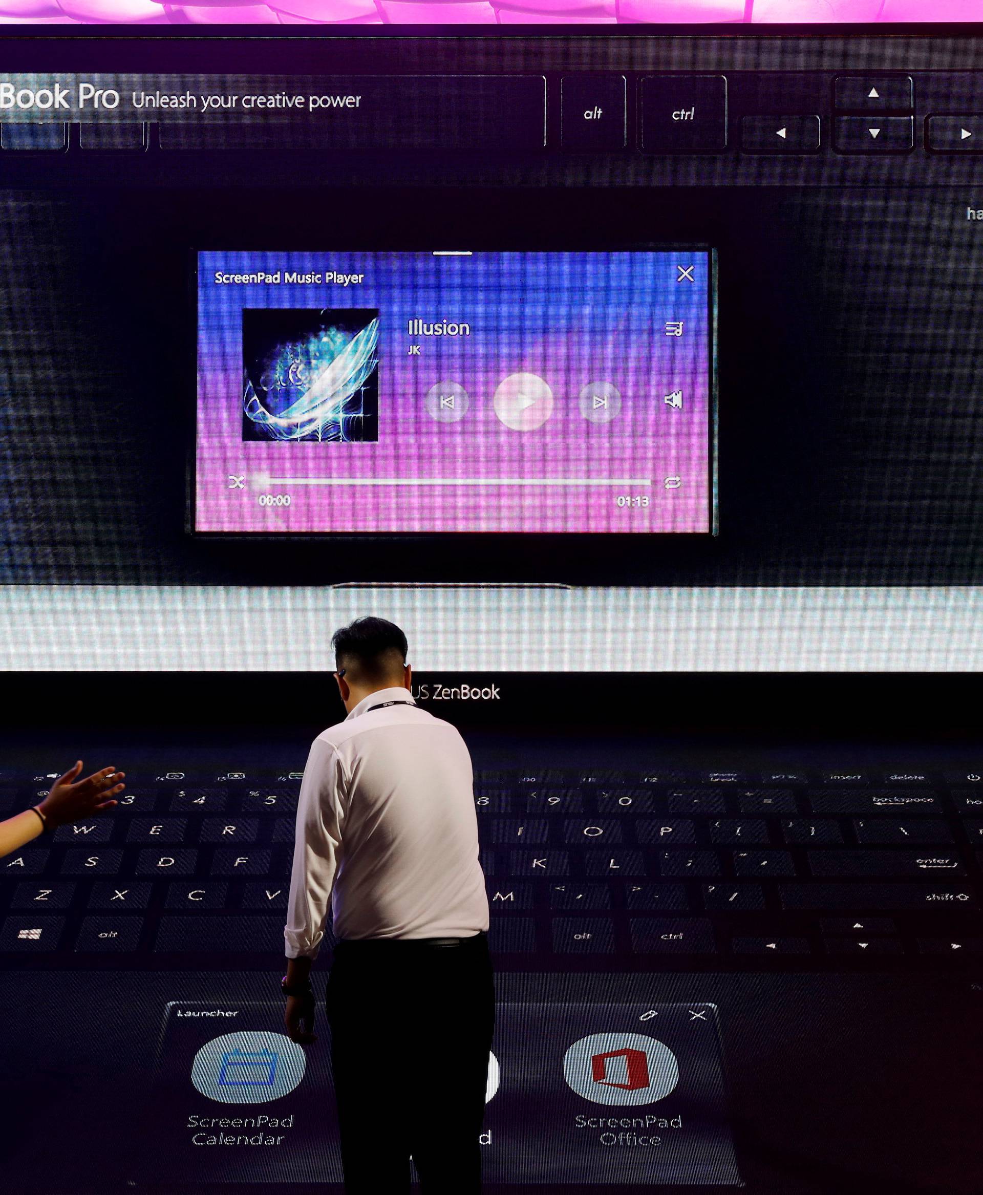 Visitors react at a booth of Asus during the annual Computex computer exhibition in Taipei