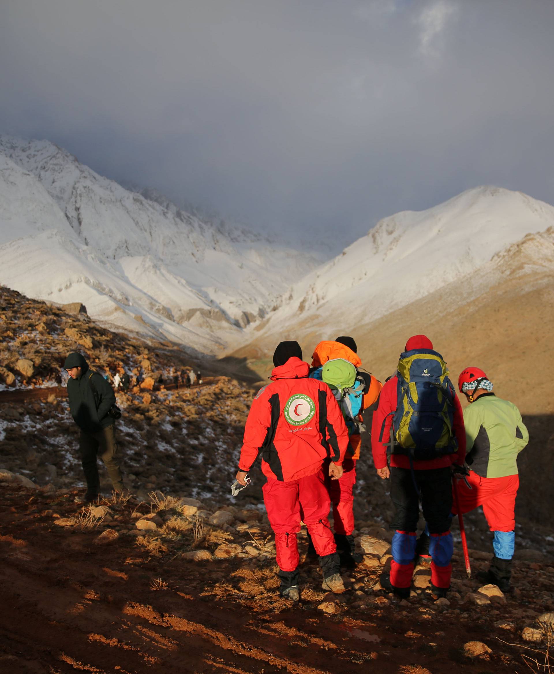 Members of emergency and rescue team search for the plane that crashed in a mountainous area of central Iran