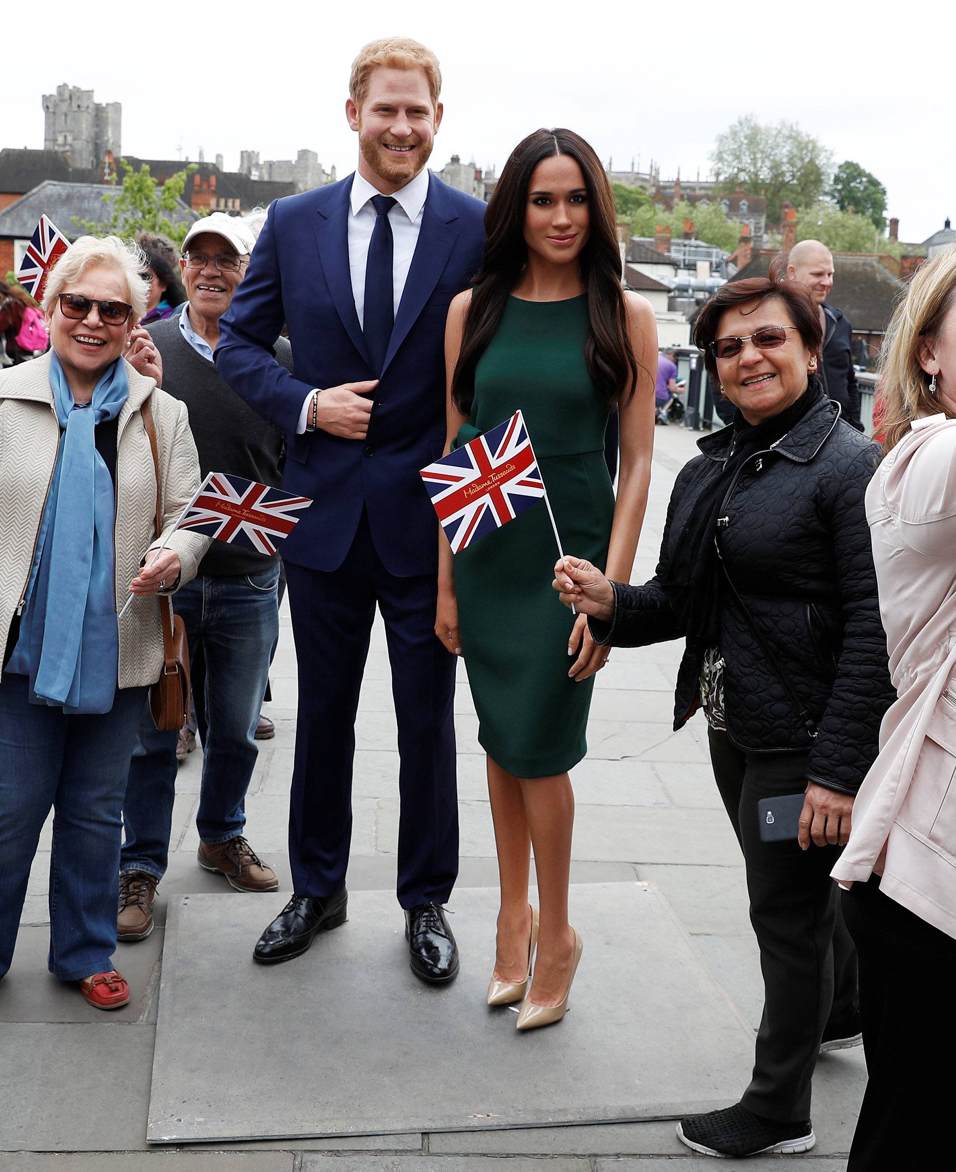People pose for pictures and selfies with models of Britain's Prince Harry and Meghan Markle ahead of their wedding, in Windsor