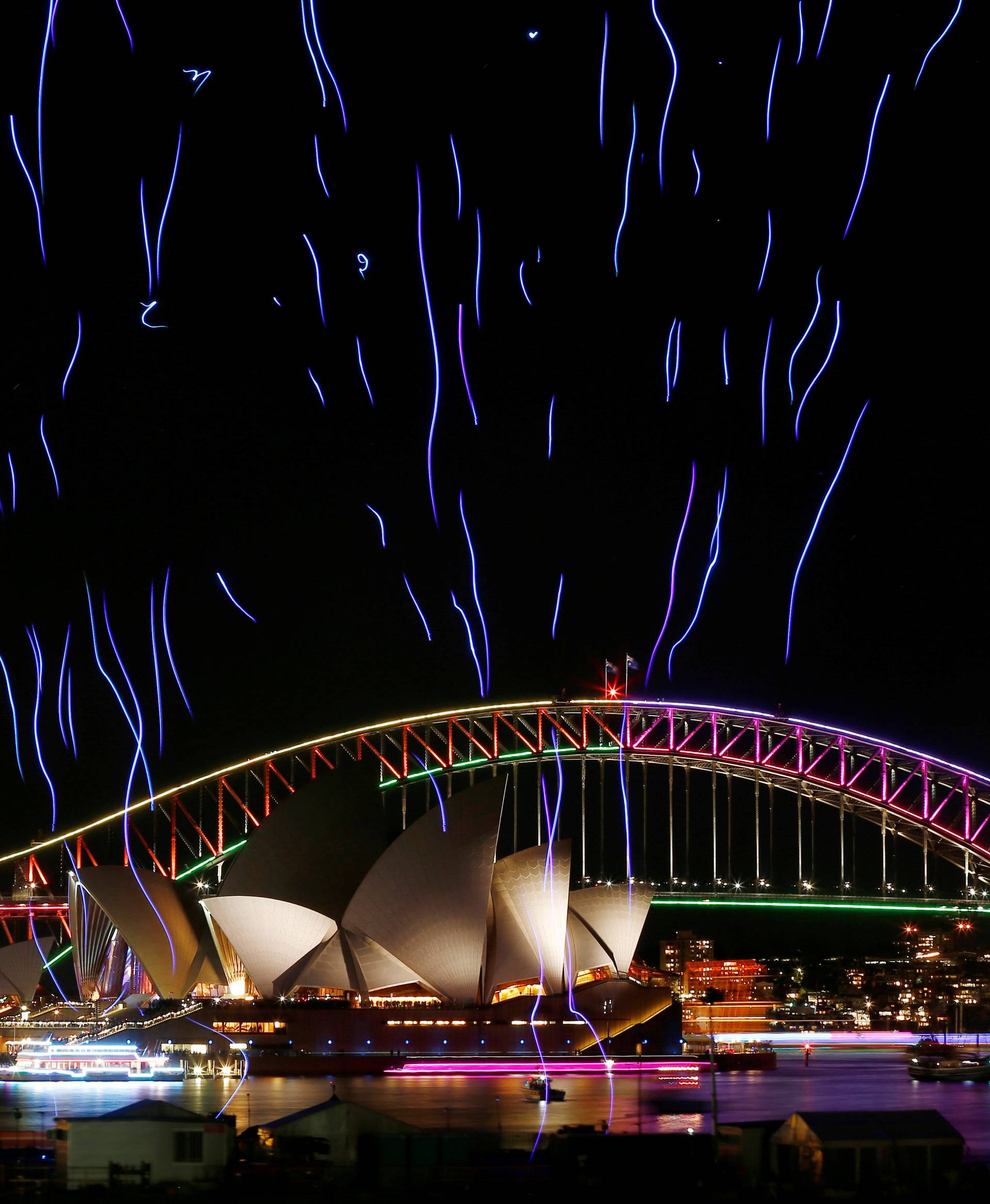 An aerial performance featuring 100 illuminated drones lift off from a barge on Sydney Harbour in front the Sydney Harbour Bridge and Opera House during the Vivid Sydney light festival in Sydney