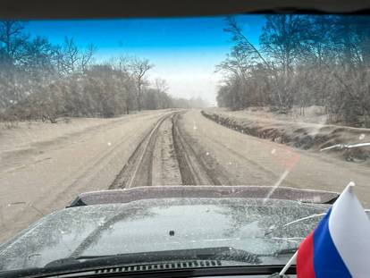 A view from inside a car shows a road covered in volcanic dust following the eruption of Shiveluch volcano in the settlement of Klyuchi