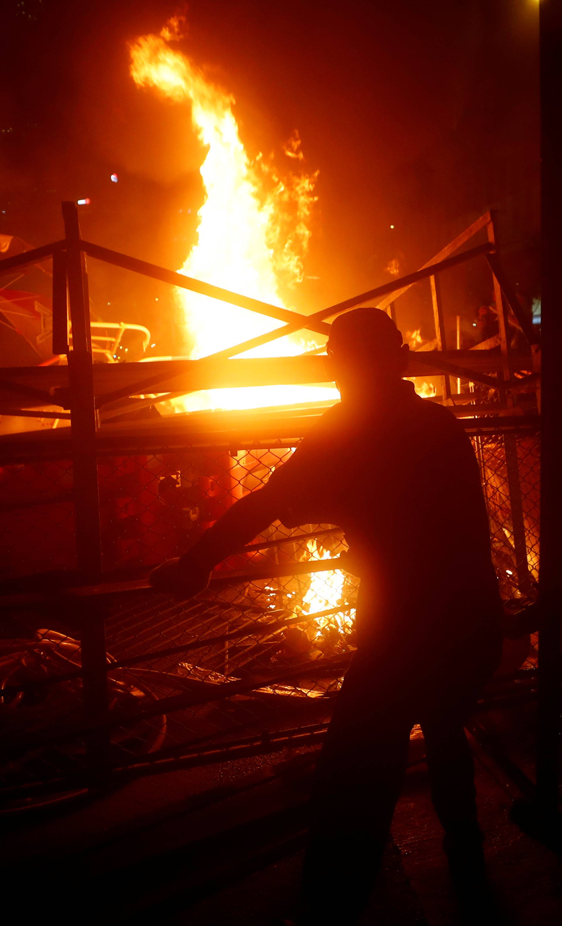 Demonstrators stand next to a burning barricade during a protest in Hong Kong