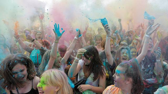People daubed in coloured powder react during the ColorFest festival at the amusement park 'Dreamland' in Minsk