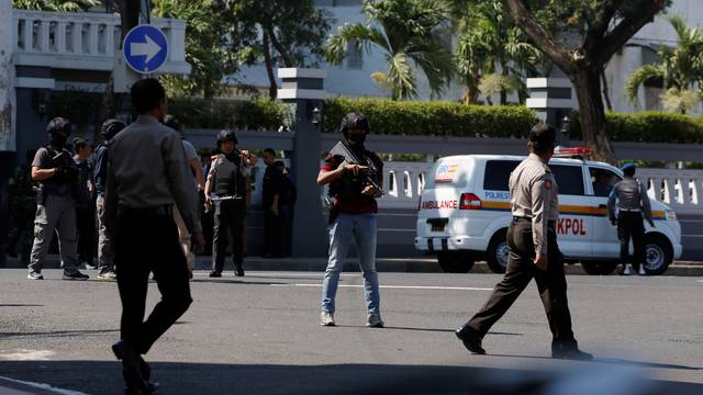 Anti-terror policemen stand guard following a bomb blast in front of a police office in Surabaya