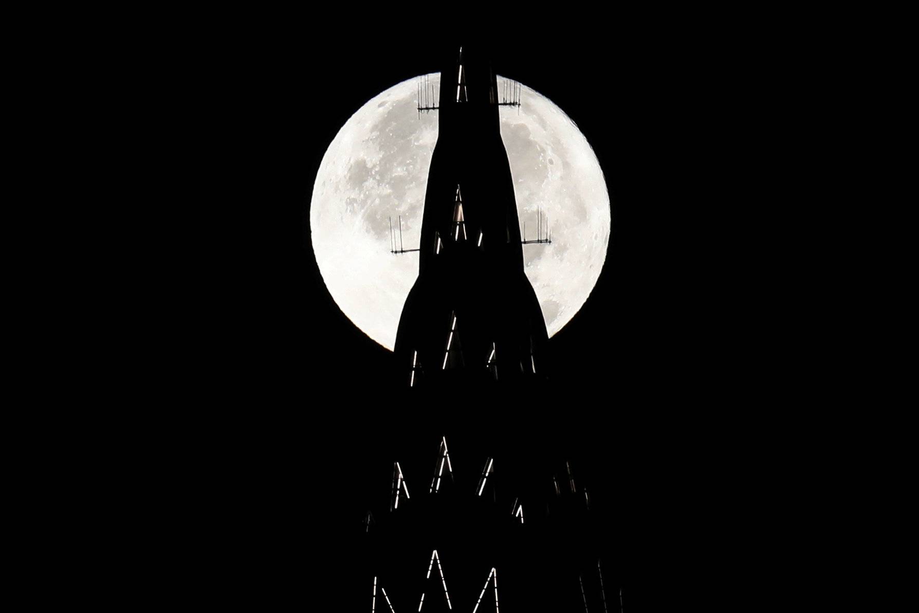 The supermoon sets behind the Chrysler Building in New York