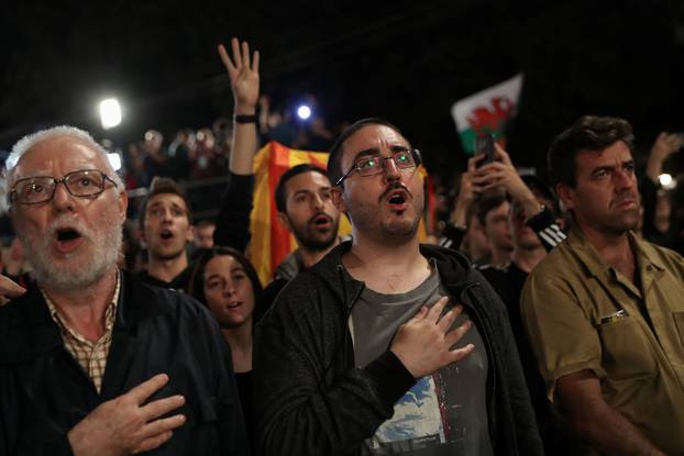 People sing during a gathering at Plaza Catalunya after voting ended for the banned independence referendum, in Barcelona