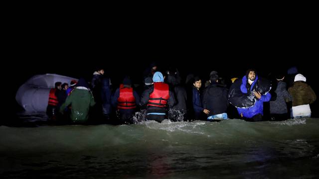 FILE PHOTO: Migrants launch their dinghy from the shores of northern France in attempt to reach Britain