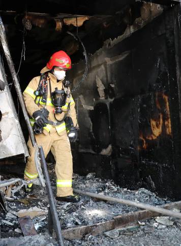 A firefighter walks out of a burnt hospital in Miryang