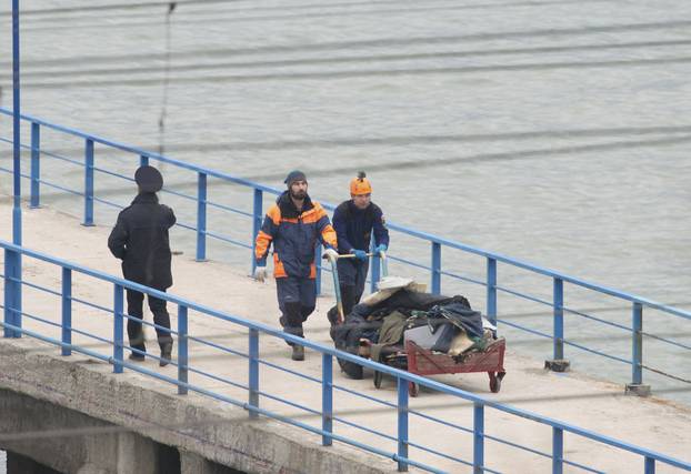 Russian Emergencies Ministry members push cart with remains of Russian military Tu-154 plane which crashed into Black Sea at quay in Sochi suburb of Khosta