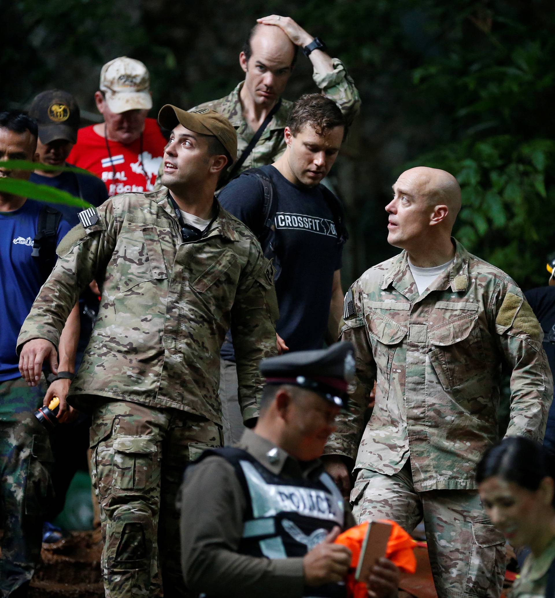 U.S. military personnel come out from Tham Luang cave complex during a search for members of an under-16 soccer team and their coach, in the northern province of Chiang Rai