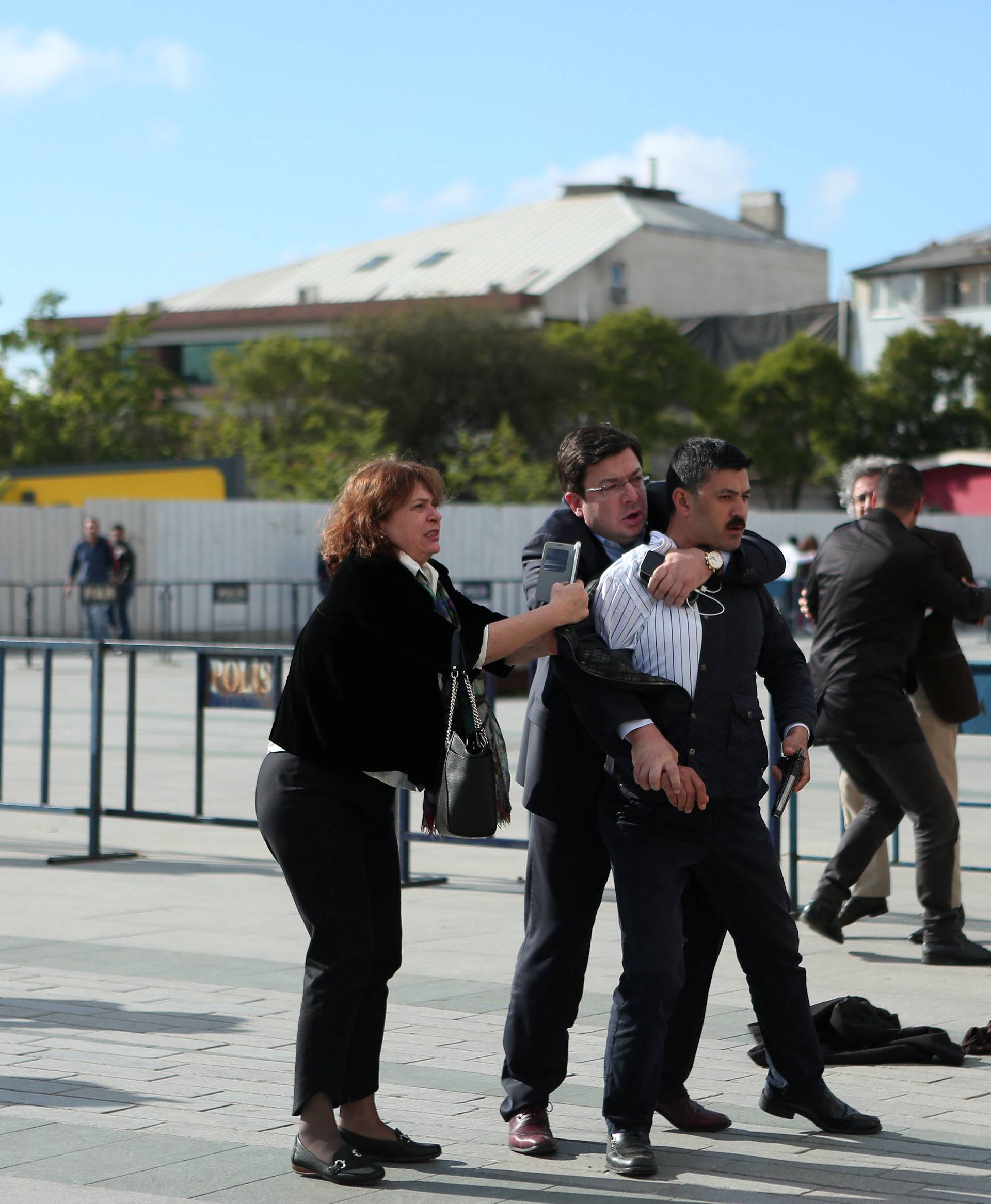 An assailant who attempted to shoot prominent Turkish journalist Can Dundar is caught by Dilek Dundar, wife of Can Dundar, and an unidentified man outside a courthouse in Istanbul