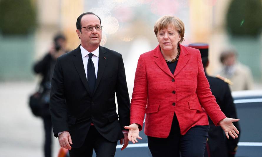 French President Francois Hollande welcomes German Chancellor Angela Merkel during arrivals for a Franco-German-Italian-Spanish summit ahead of the upcoming EU Summit in Versailles
