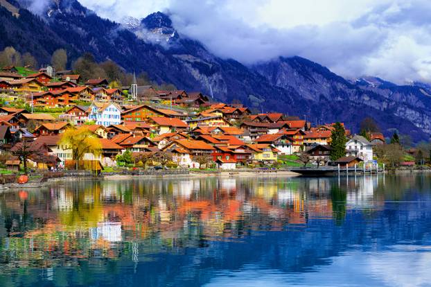 Old town and Alps mountains reflecting in lake, Switzerland