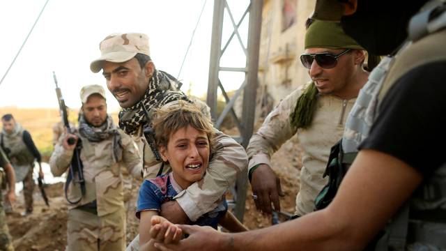 A boy reacts as Iraqi soldiers help him to walk out the front line during a battle with Islamic State in the Intisar disrict of eastern Mosul