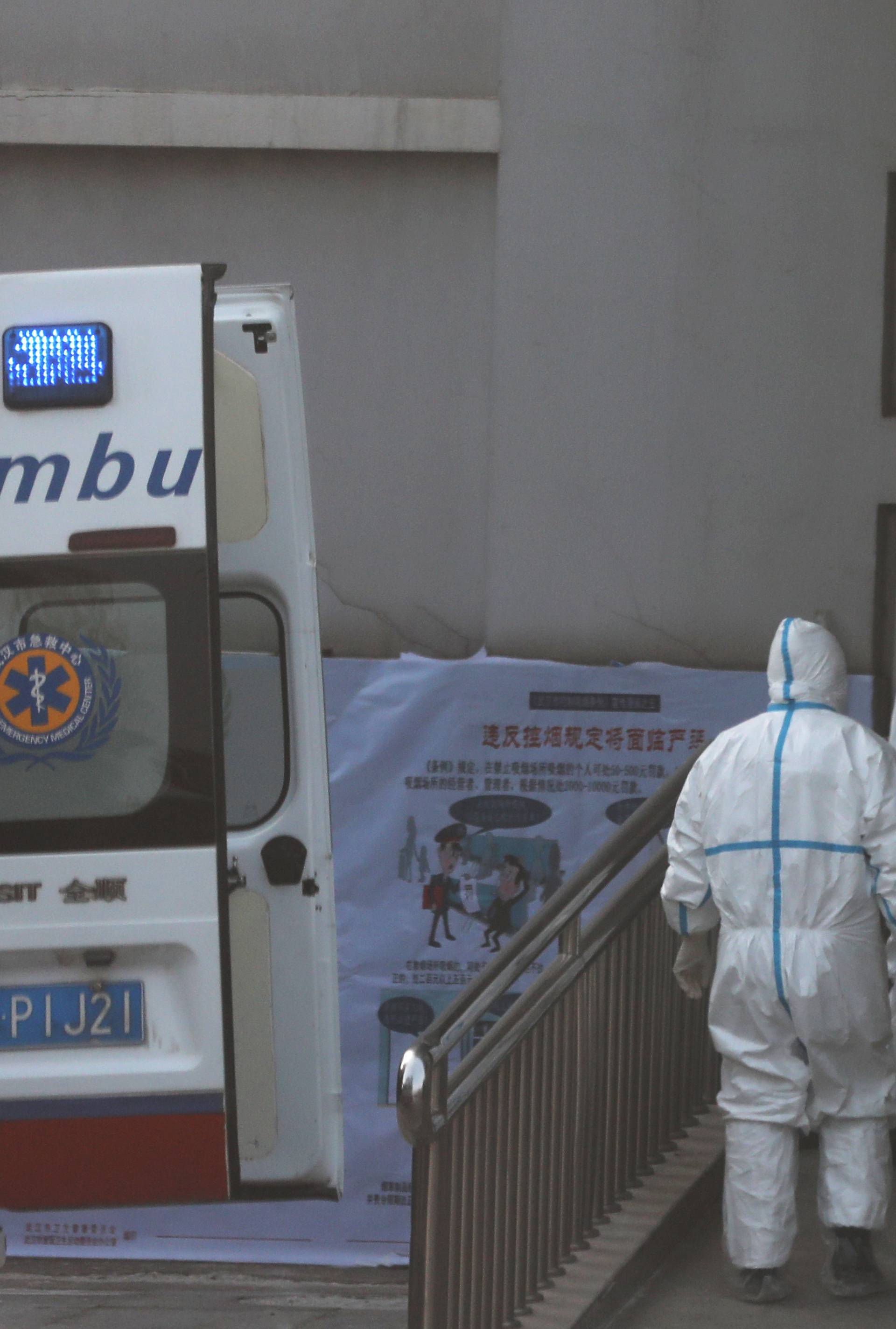 Medical staff transfer a patient from an ambulance at the Jinyintan hospital, where the patients with pneumonia caused by the new strain of coronavirus are being treated, in Wuhan