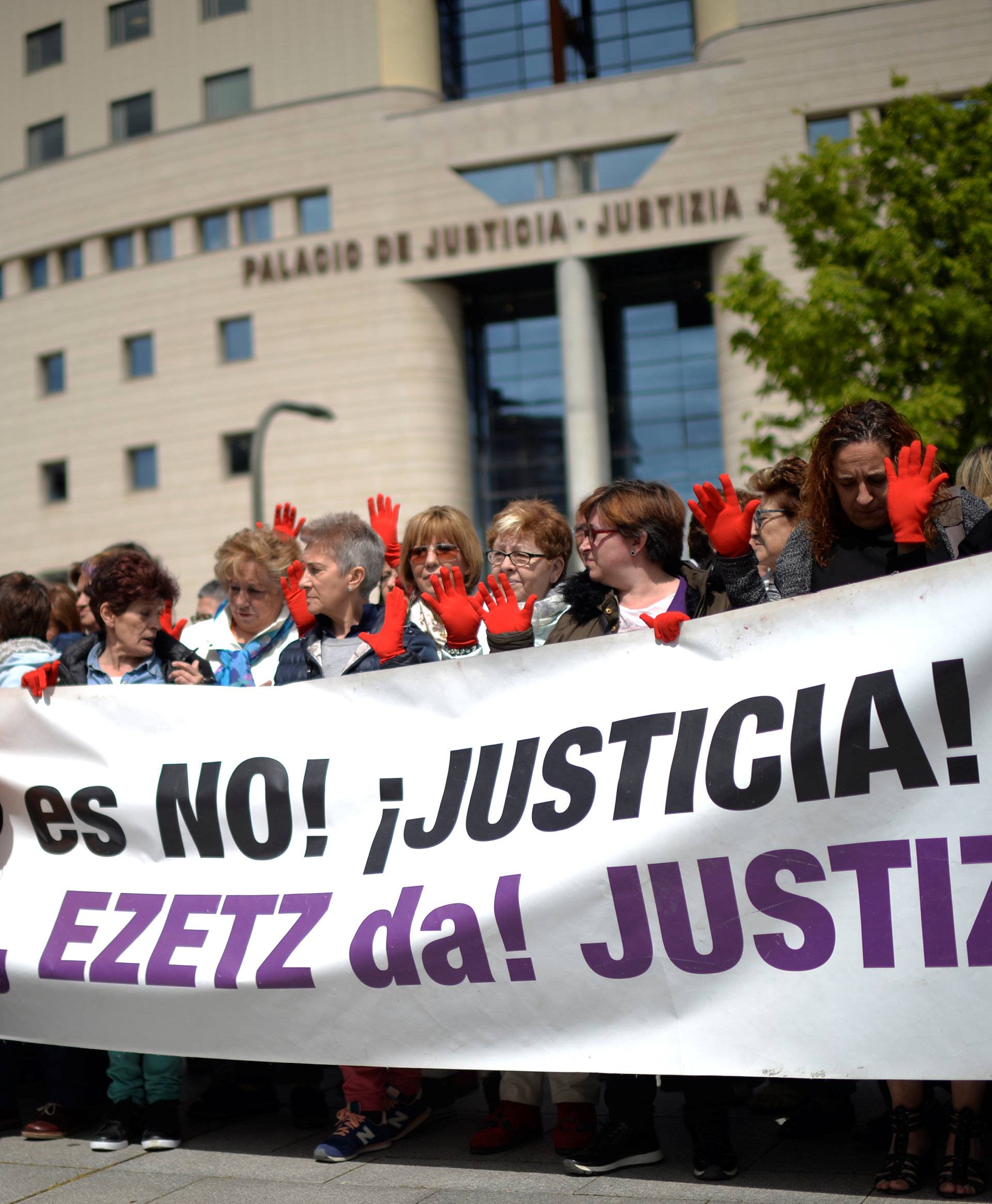 Protesters gather outside the High Court of Navarra behind a banner reading "No is No! Justice!" While awaiting a verdict on five men accused of the multiple rape of a woman during Pamplona's San Fermin festival