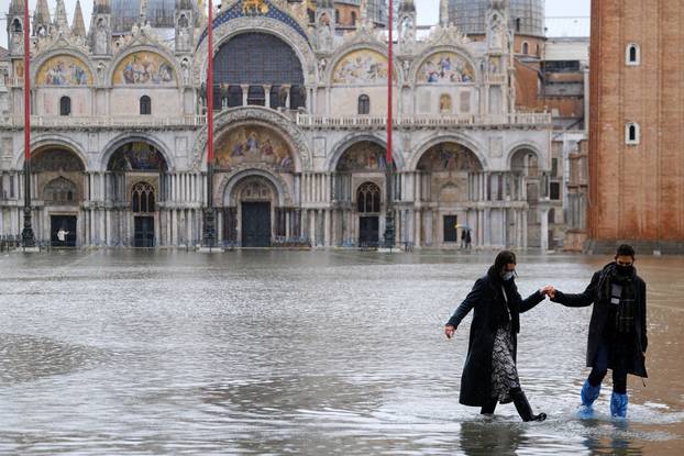 A couple walks in the flooded St. Mark