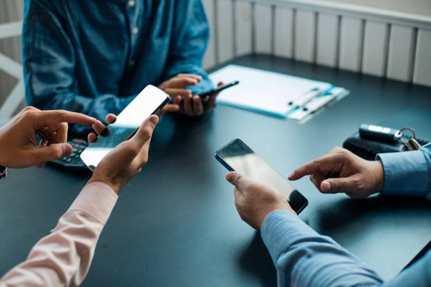 Young business people using smartphone on wooden table share dat