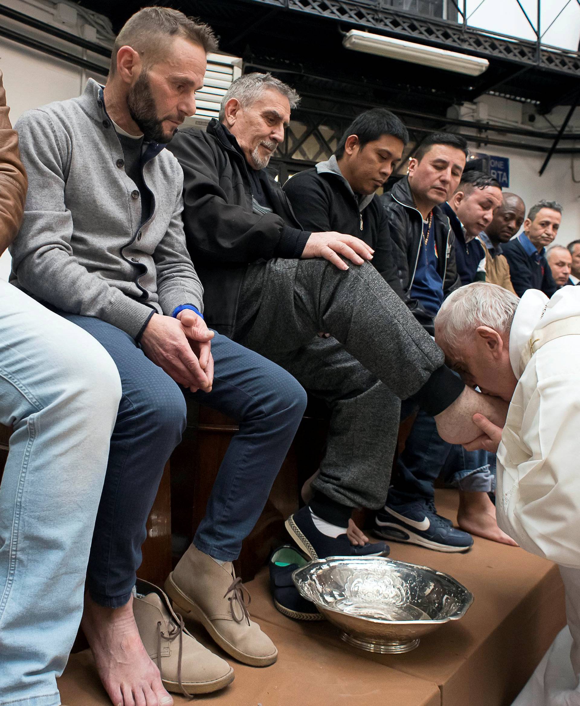 Pope Francis kisses the foot of a inmate at the Regina Coeli prison during the Holy Thursday celebration in Rome