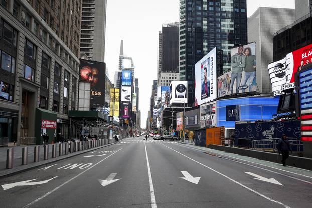 People walk through a nearly empty Times Square, during the outbreak of coronavirus disease (COVID-19) in New York