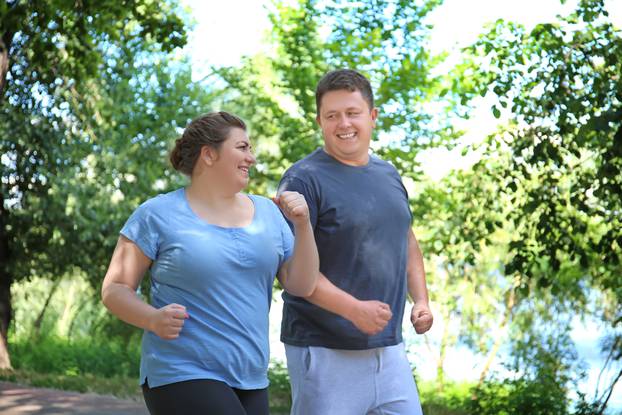 Overweight,Couple,Running,In,Green,Park
