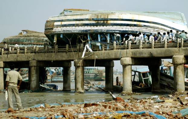 FILE PHOTO: Onlookers look at damaged fishing trawlers stuck on a bridge in Nagapattinam port