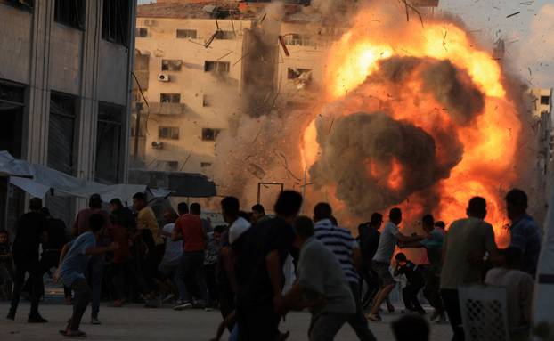 Smoke and flames rise as a residential building collapses after an Israeli air strike, in Gaza City