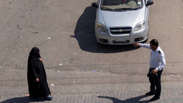 A traffic policeman directs vehicles amid high temperatures in Nassiriya