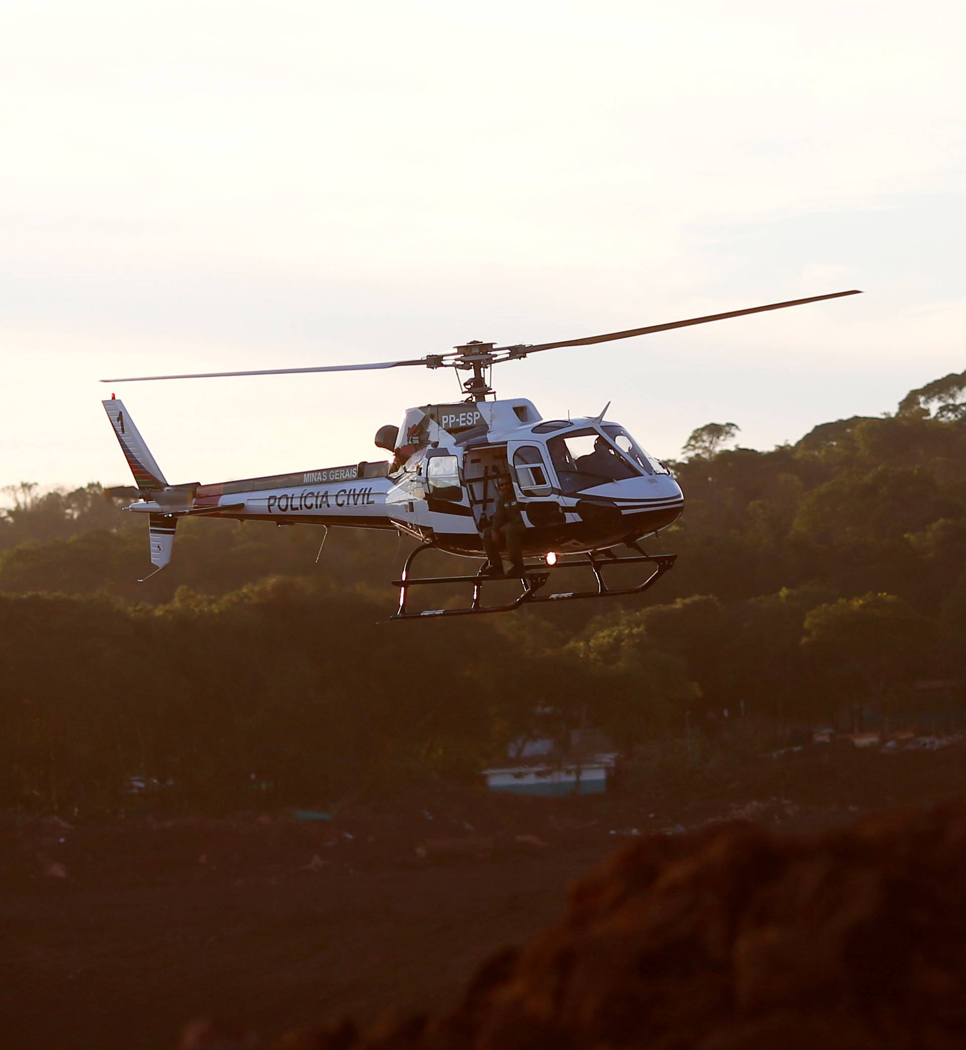 A rescue helicopter flies after a tailings dam owned by Brazilian mining company Vale SA collapsed, in Brumadinho