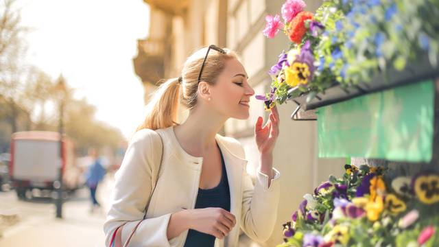 Beautiful,Woman,Smelling,Flowers,On,The,Street