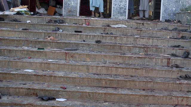 Afghan men stand inside a mosque after a blast, in Kunduz