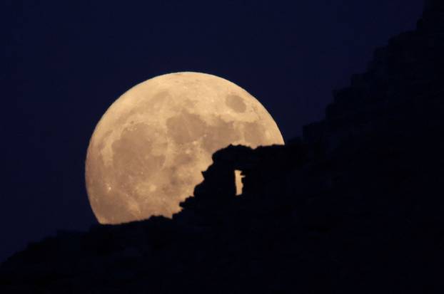Full moon rises behind the Pyramids of Giza in Egypt